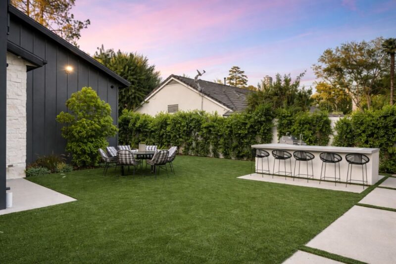 Uređeno dvorište sa zonama za sedenje i kuhinjom na otvorenom