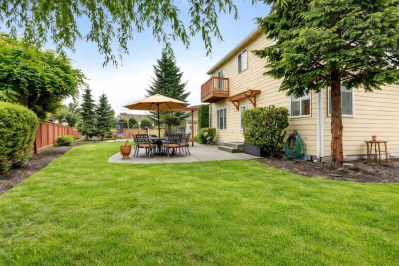 Alt text: Dvorište sa nameštajem i suncobranom prilagođeno različitim vremenskim uslovima