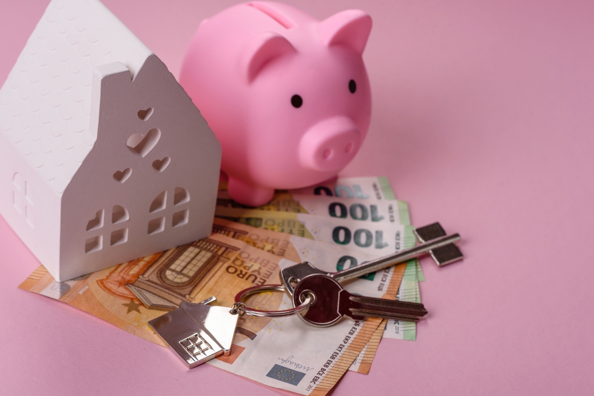 prikaz kuće, kasice prasice, ključeva i novca an roze pozadini